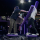 An image of two people fighting with purple noodles while standing on planks in the Lenovo Legion foam pit.